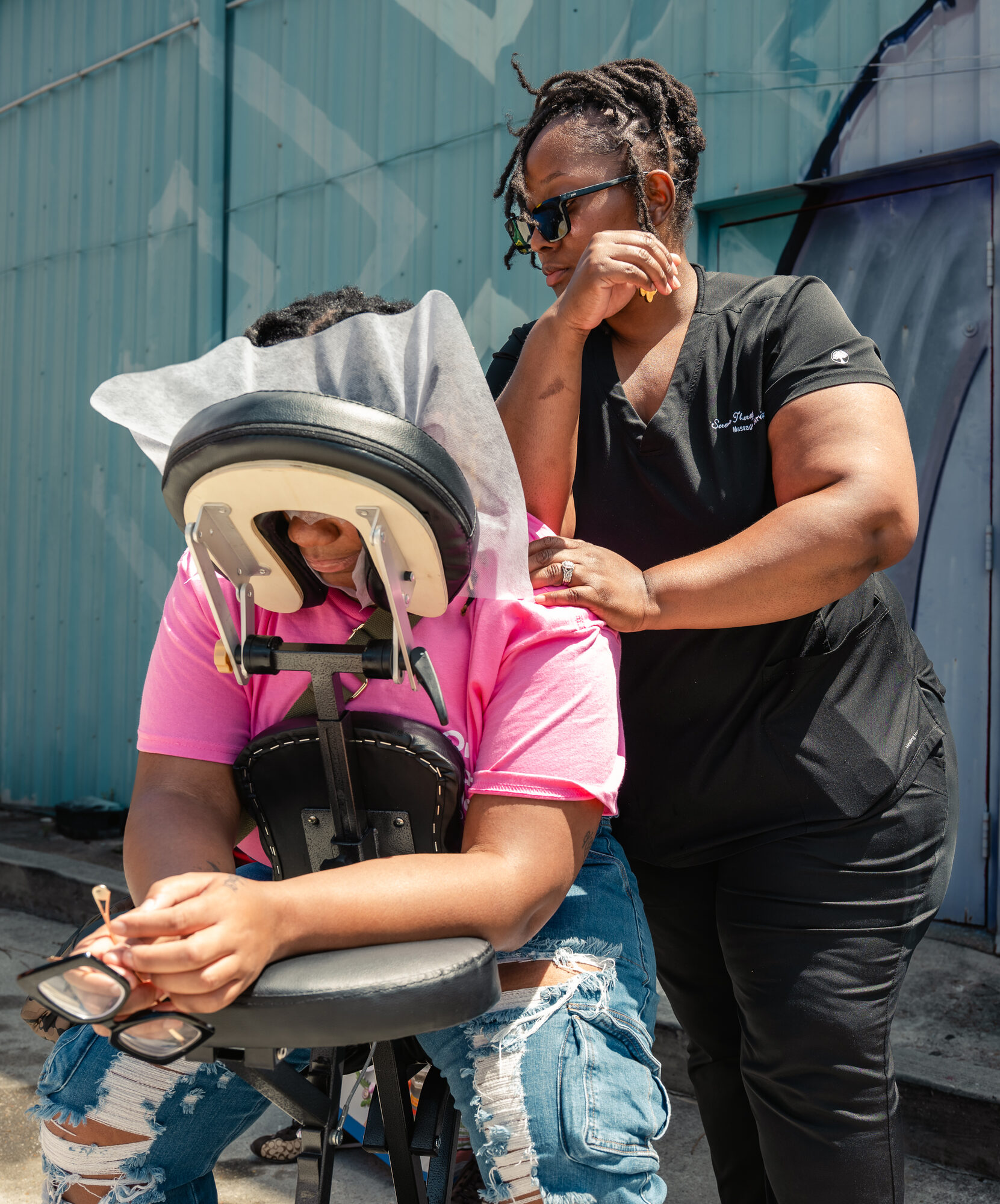A mother receiving a chair massage at the Block Party