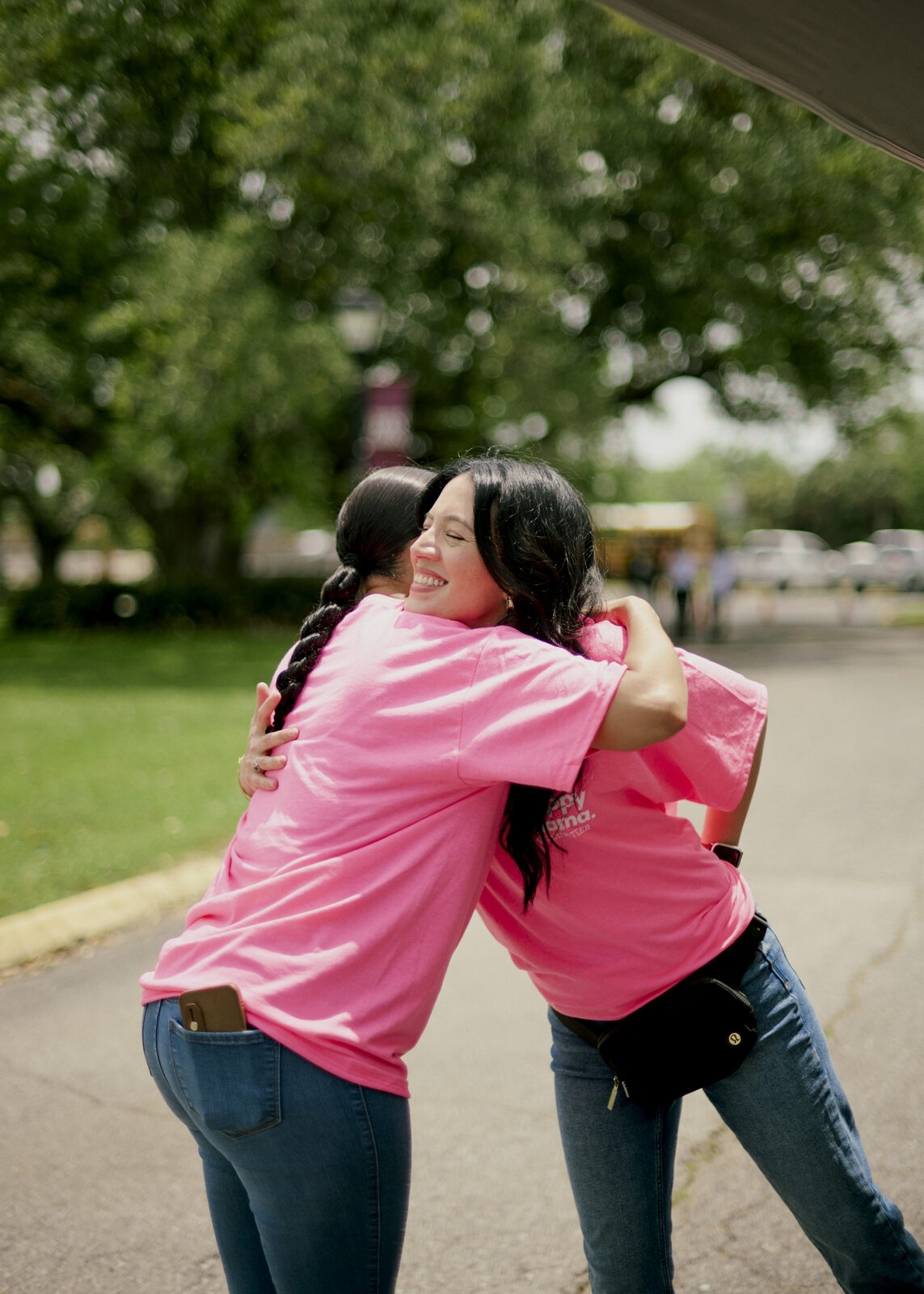 Two members of the One Happy Mama community embracing at an event
