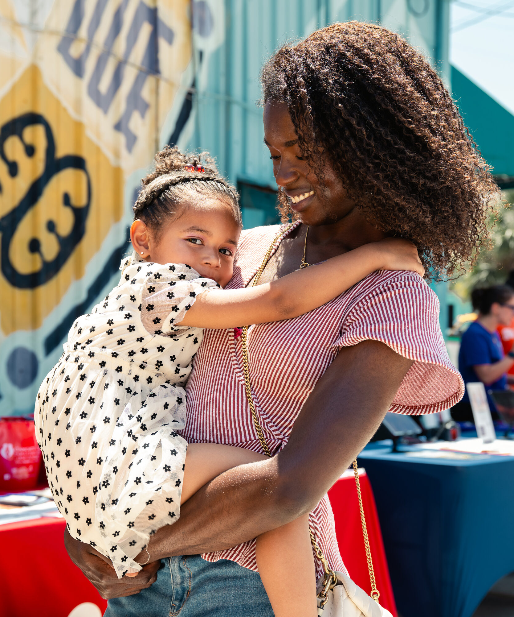 A mother and her child connecting with a resource partner at the Rooted in Love Block Party