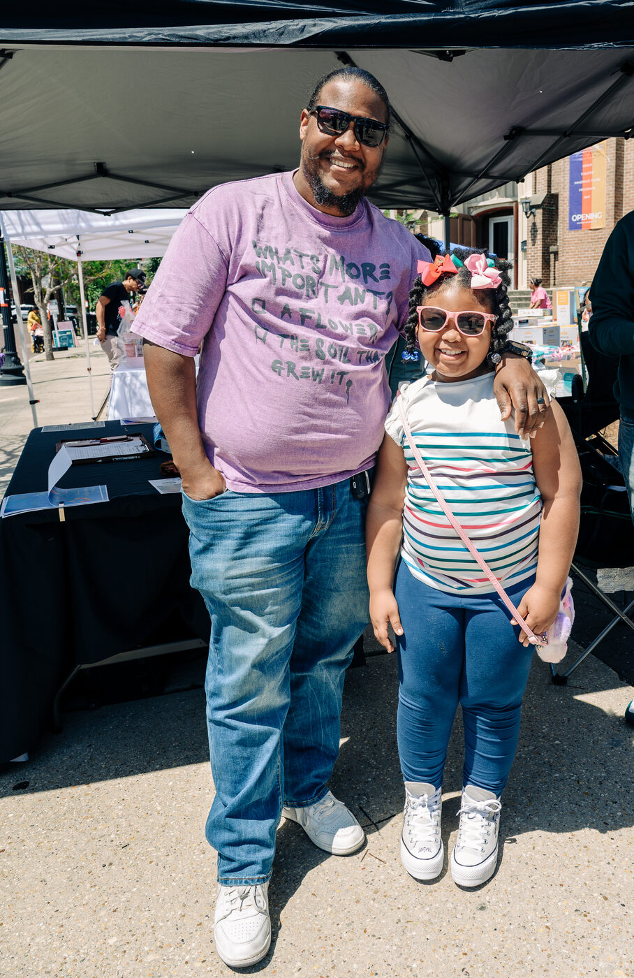 A father and daughter at a Rooted in Love partner tent